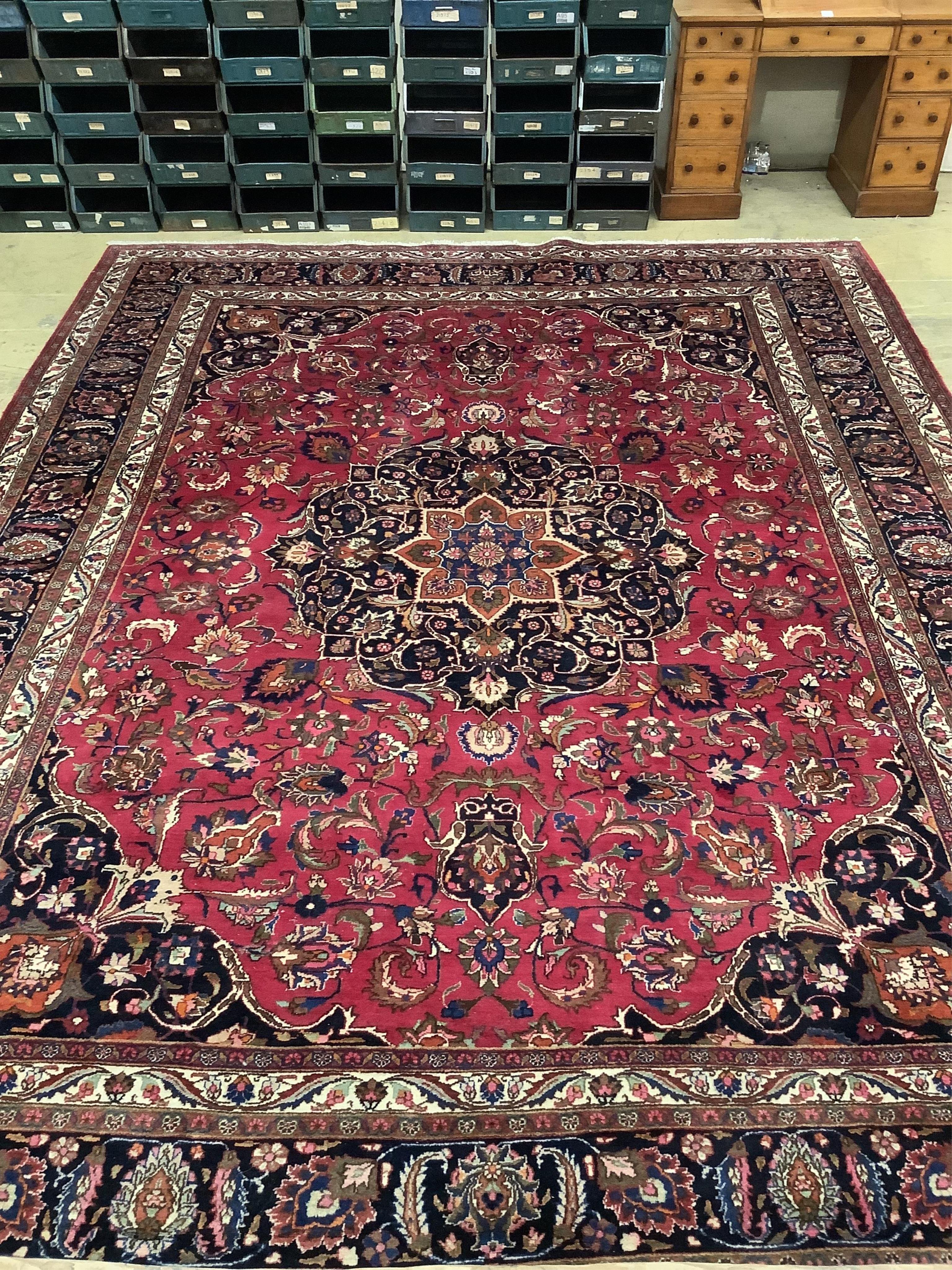 A Heriz burgundy ground floral carpet, 392cm x 299cm. Condition - good